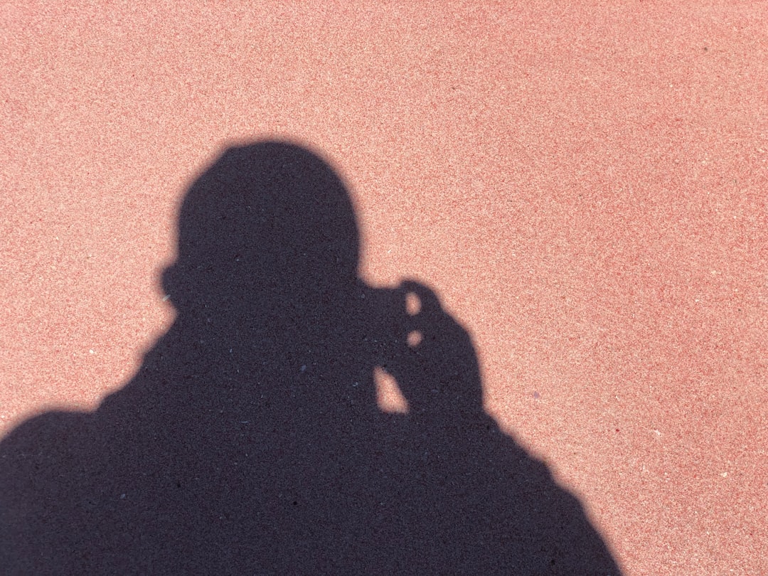 a shadow of a person talking on a cell phone