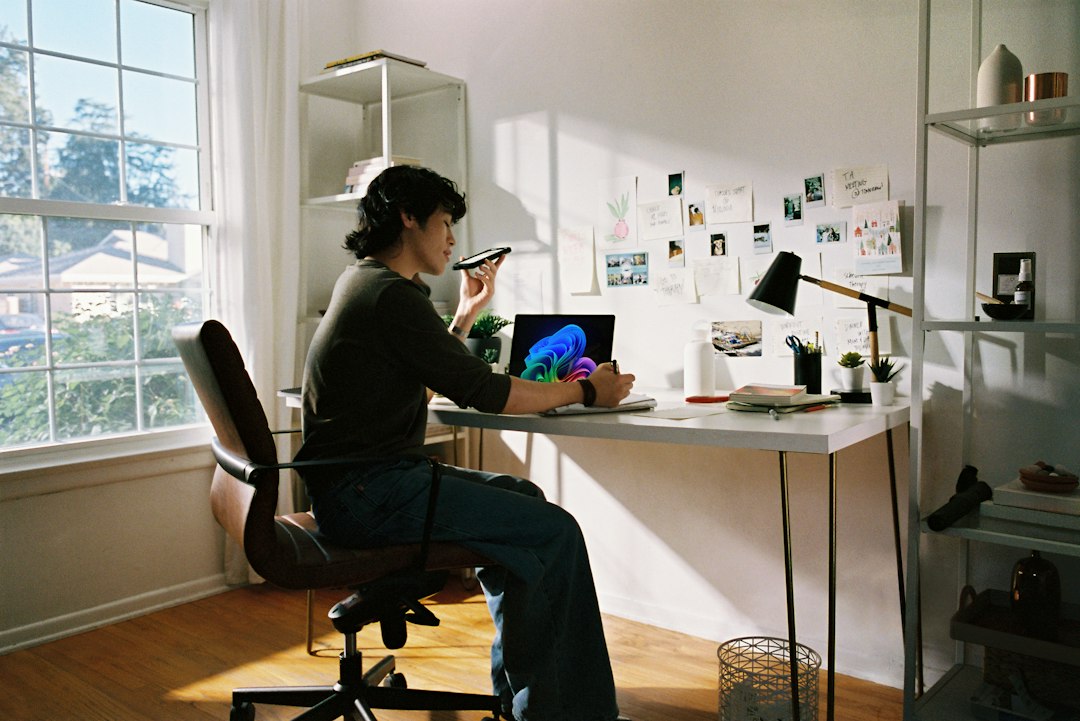 Person working at a desk with a laptop and phone