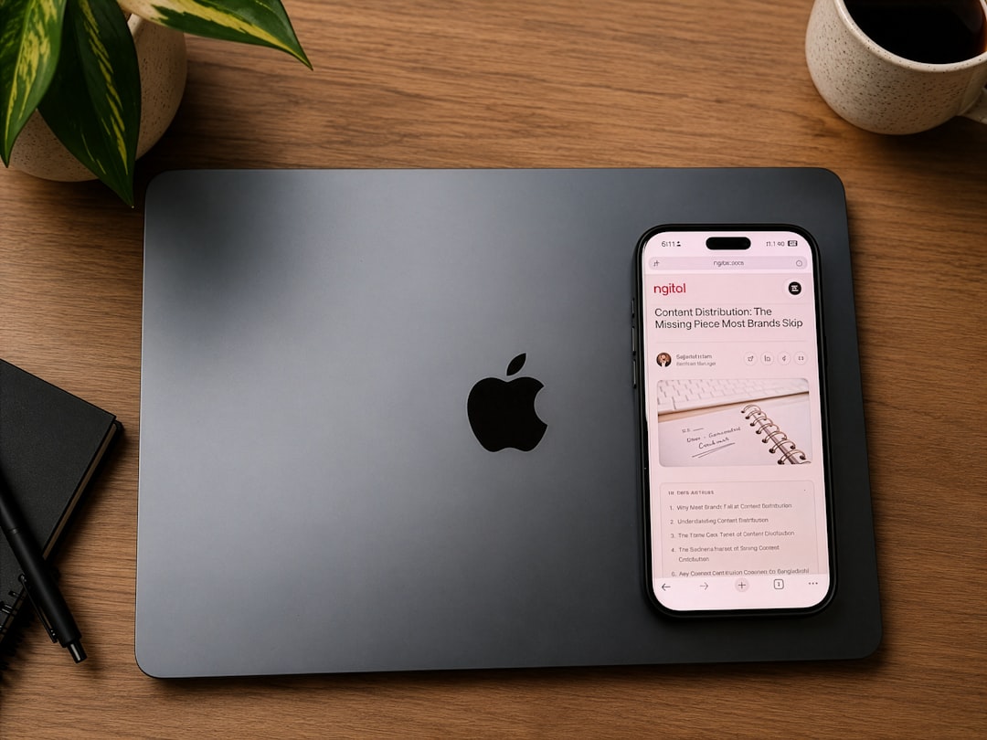 Apple laptop, smartphone, and coffee mug on a wooden desk