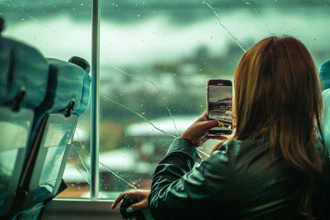 A woman taking a picture of a broken window