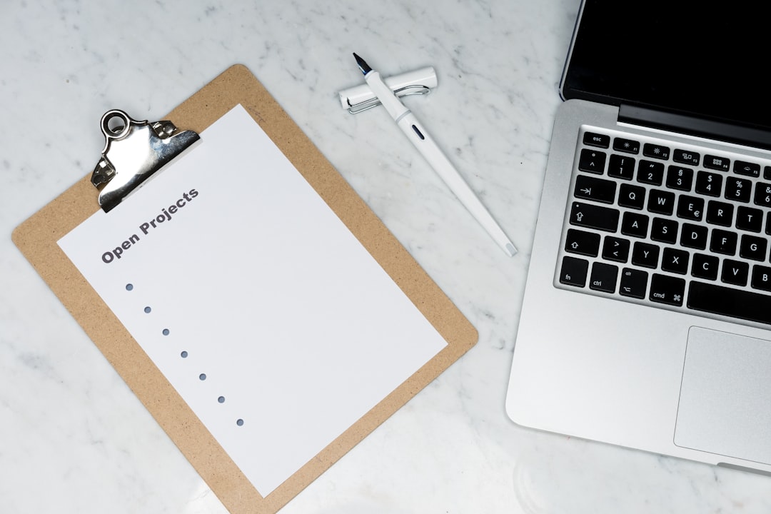 papel de impresora blanco junto a un ordenador portátil plateado