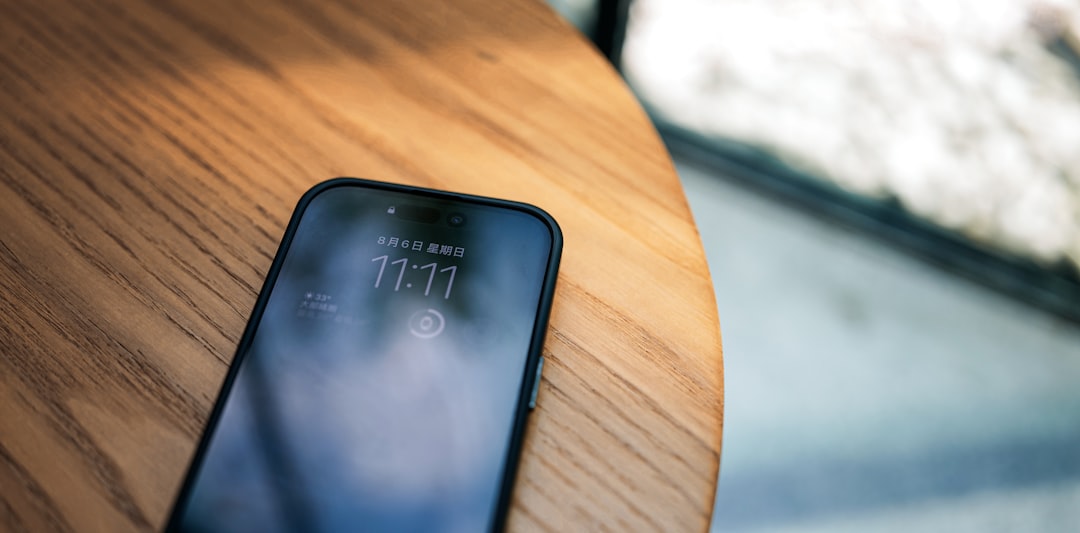 a cell phone sitting on top of a wooden table