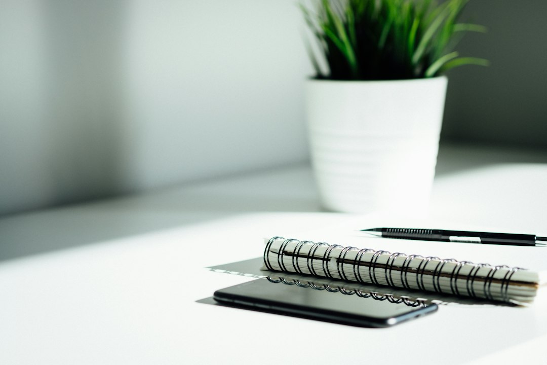 bolígrafo, cuaderno y smartphone sobre una mesa